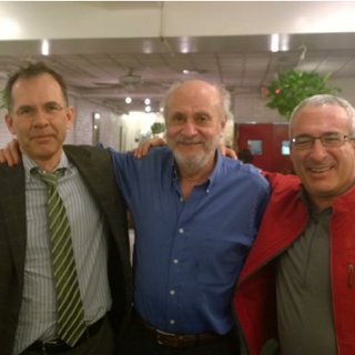 Three men standing close to each other